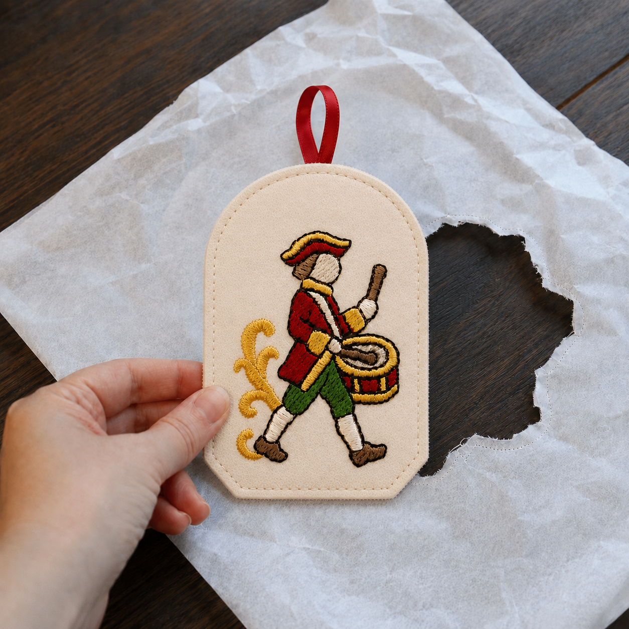 Finished drummer ITH ornament being removed from tear-away stabilizer