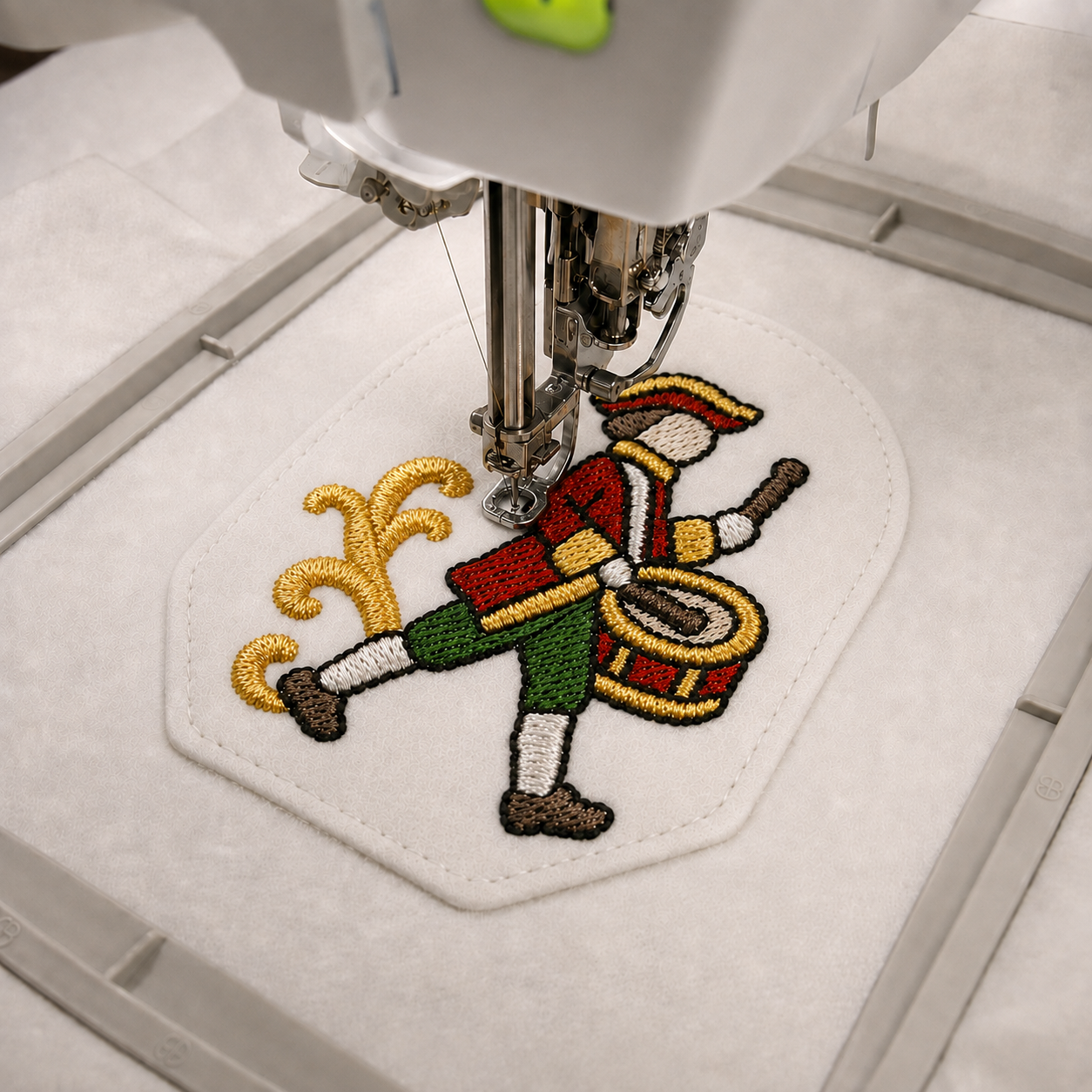 Drummer design being embroidered on the front of an ITH Christmas ornament