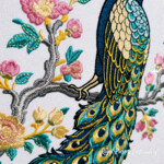 Digital machine embroidery design showing a vertical composition with a side-profile peacock, a long cascading tail with eyespot feathers, flowering branches, pink blossoms and turquoise-green leaves. The peacock plumage uses deep blue, turquoise, gold and cream shades. The design is made for large flat textile panels such as a decorative cushion front, textile wall art, the back of a jacket, a bag panel or a quilt. The archive contains four original files for mega hoops; it is a digital product, not a finished embroidery or textile item.